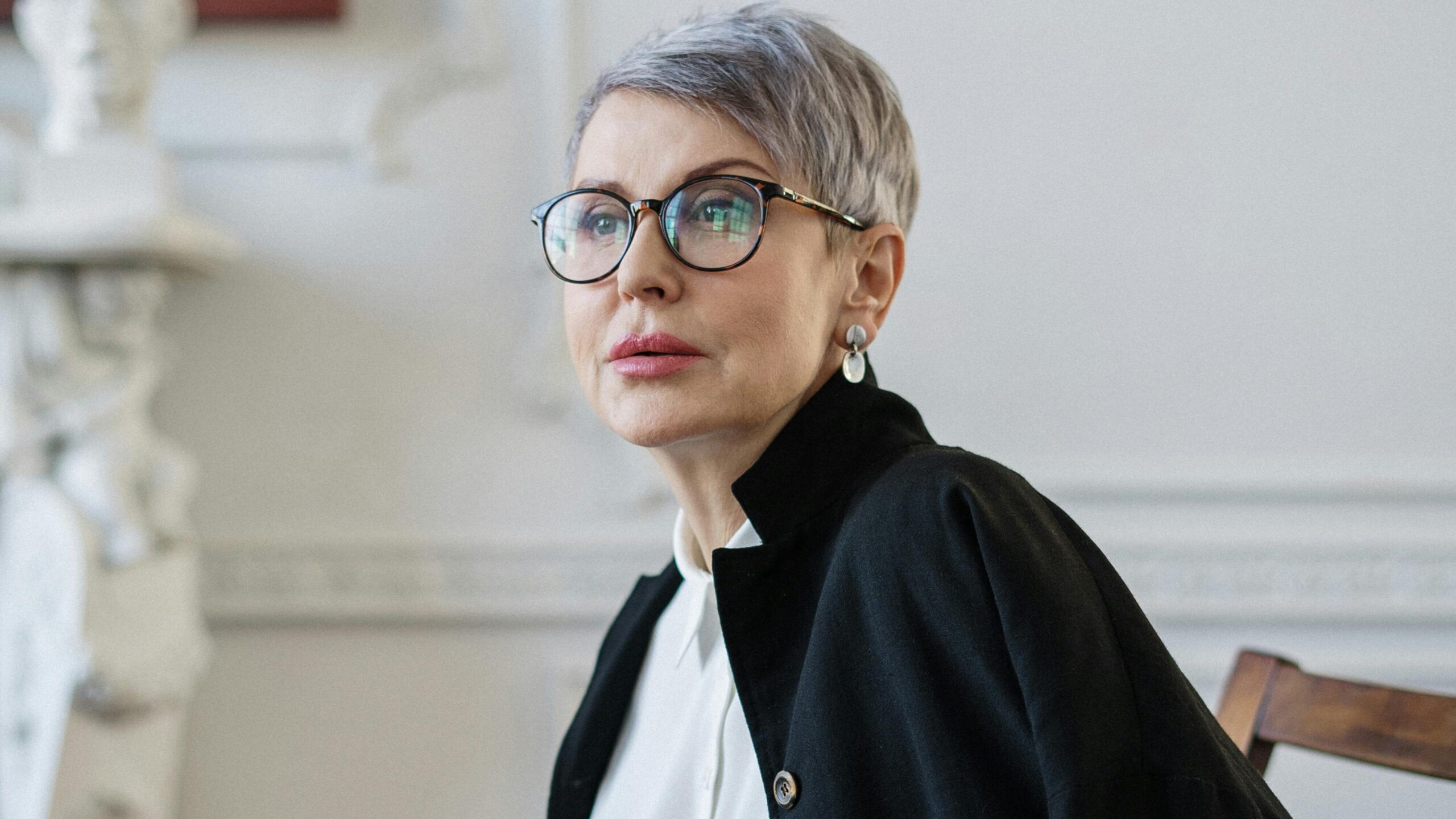 Elegante Geschäftsfrau sitzend mit Brille in der Praxis